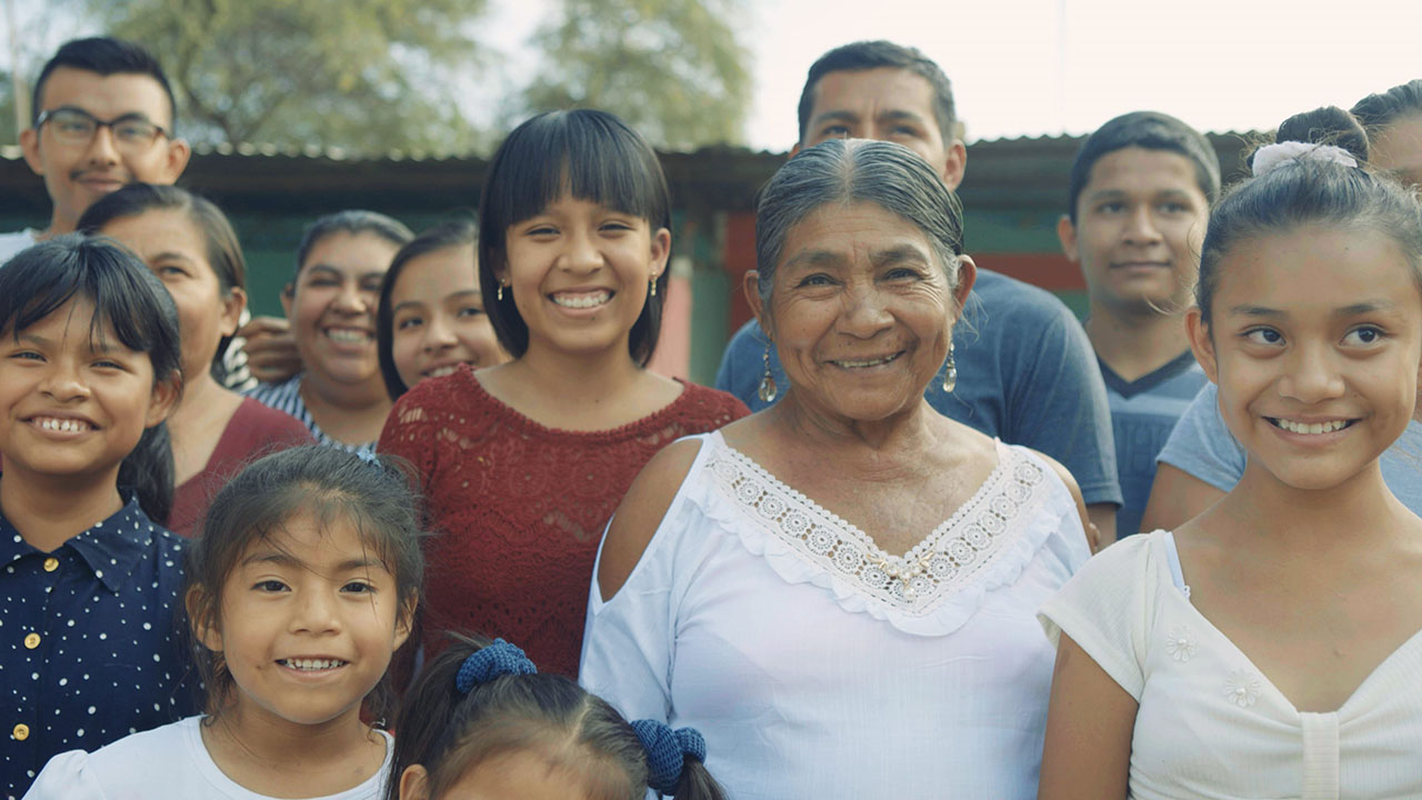 Justa More, also known as Dona Justa, poses with her granddaughter Leydi Jimena and the rest of her family in Saman, Peru.