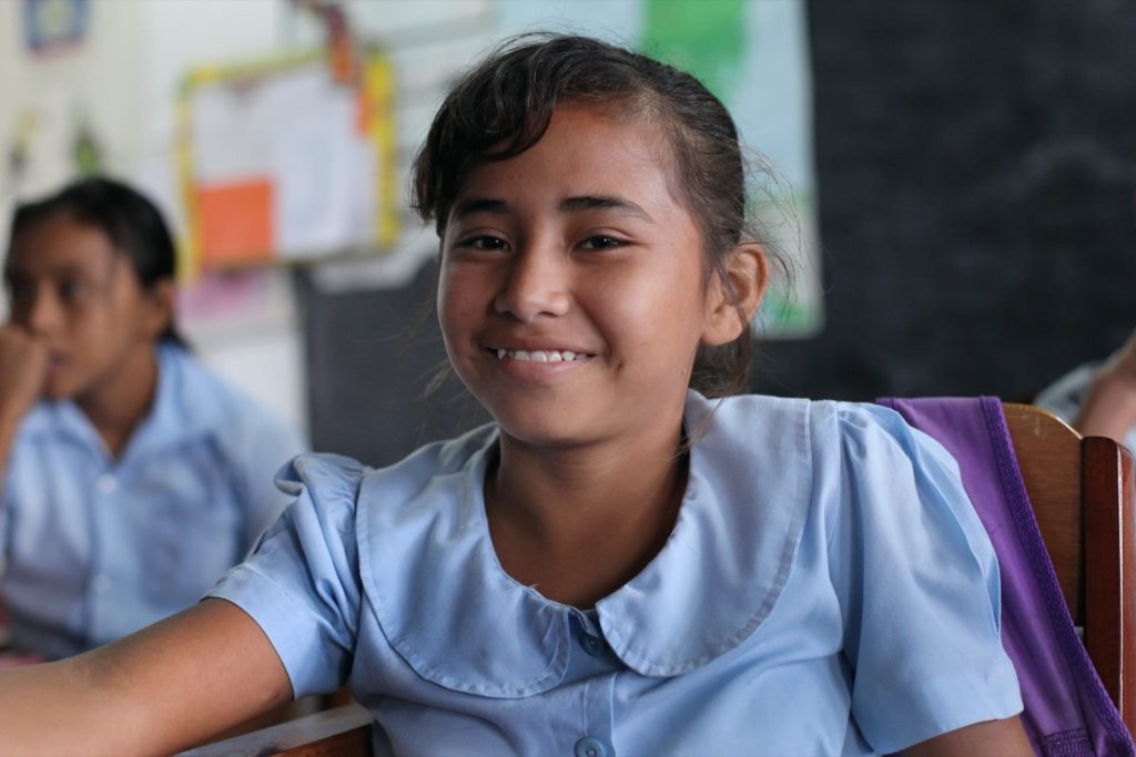 A student smiles during class at the San Narciso Roman Catholic school.